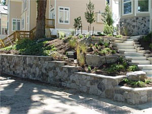 Concrete block retaining wall made attractive with stone veneer